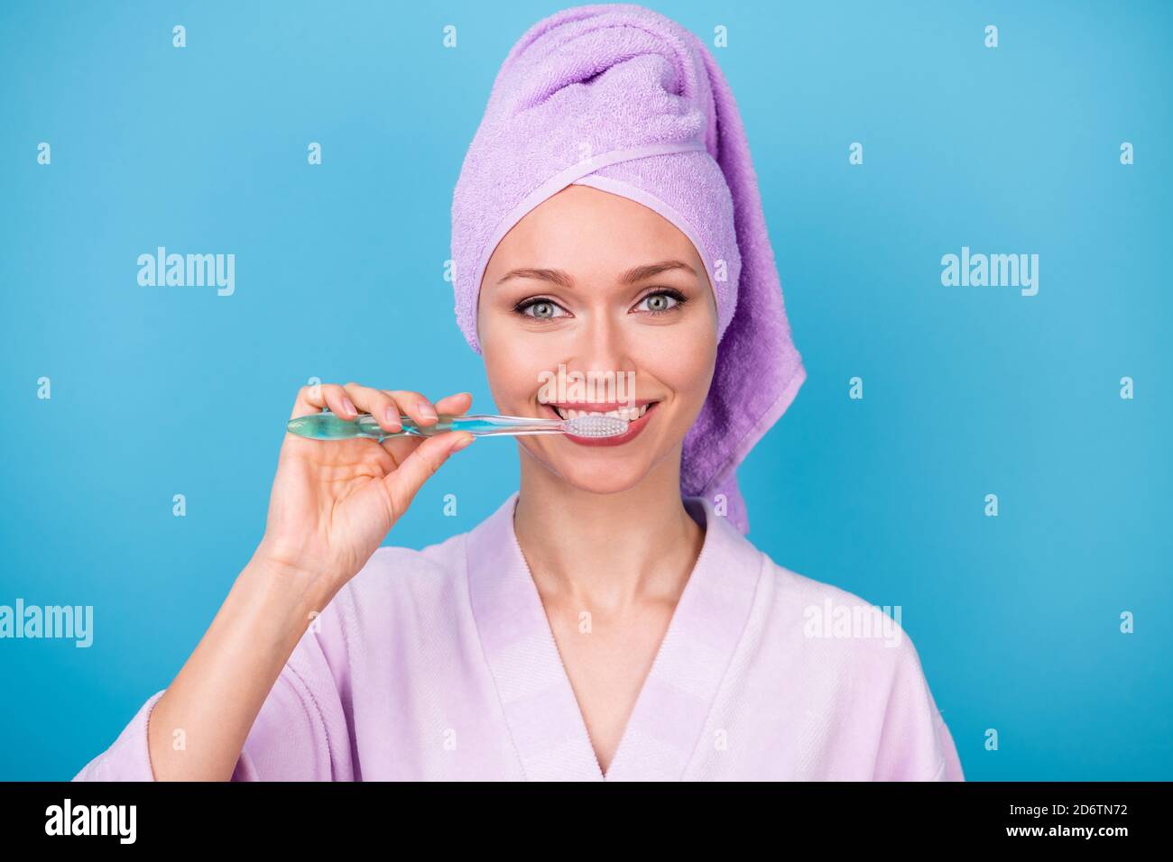 Photo of pretty young lady brushing teeth preparing wear purple towel