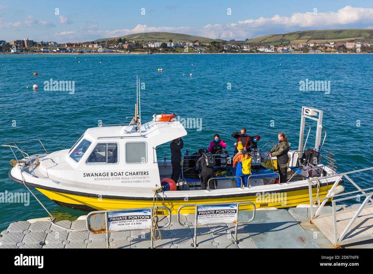 Divers on board Swanage Boat Charters boat ready to go diving at Swanage, Dorset UK in October, wearing face masks during Covid19 Coronavirus pandemic Stock Photo