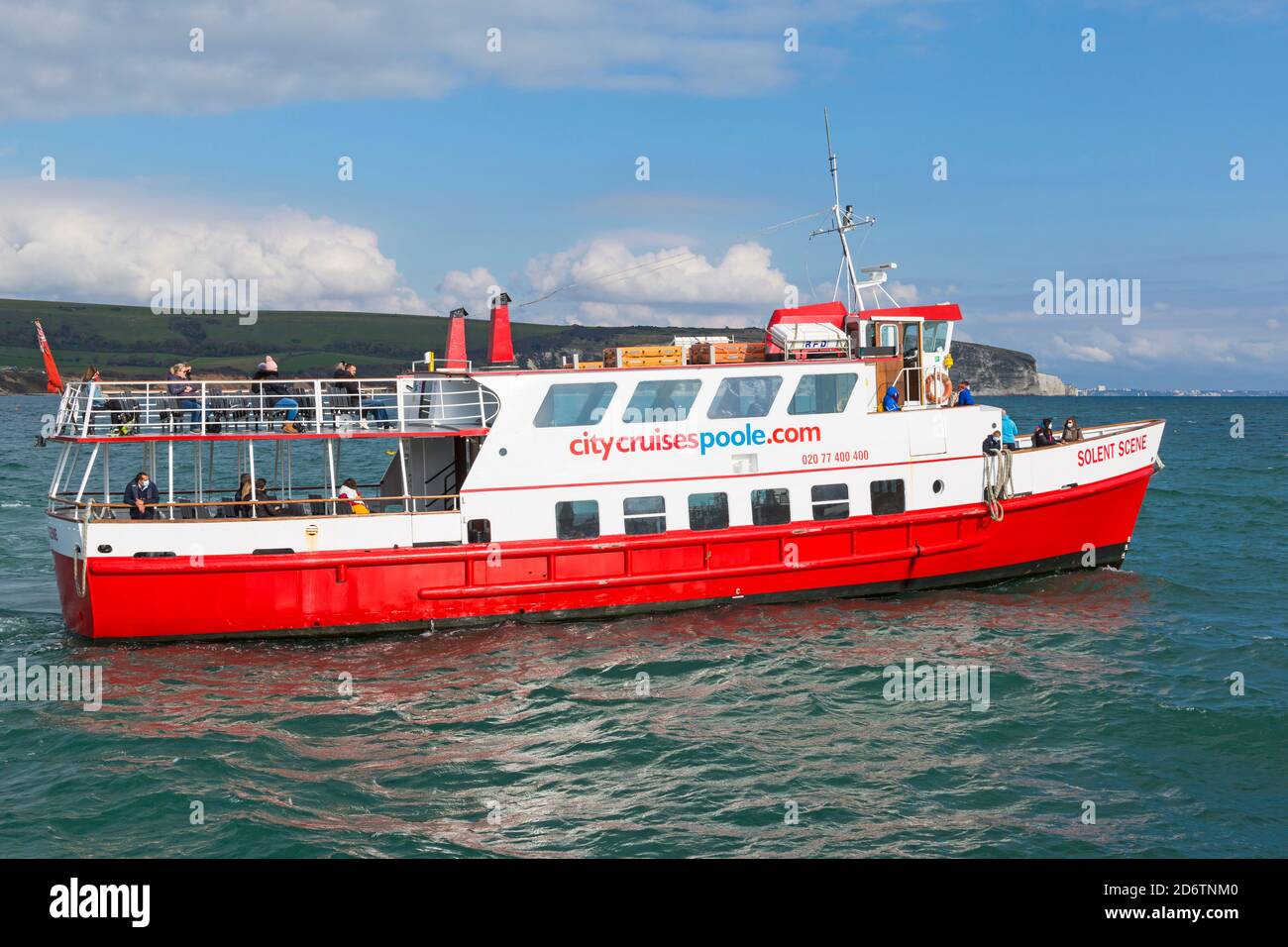 Passengers enjoy a trip along the coastline and around the bay on the Solent Scene boat arriving in Swanage, Dorset UK in October Stock Photo