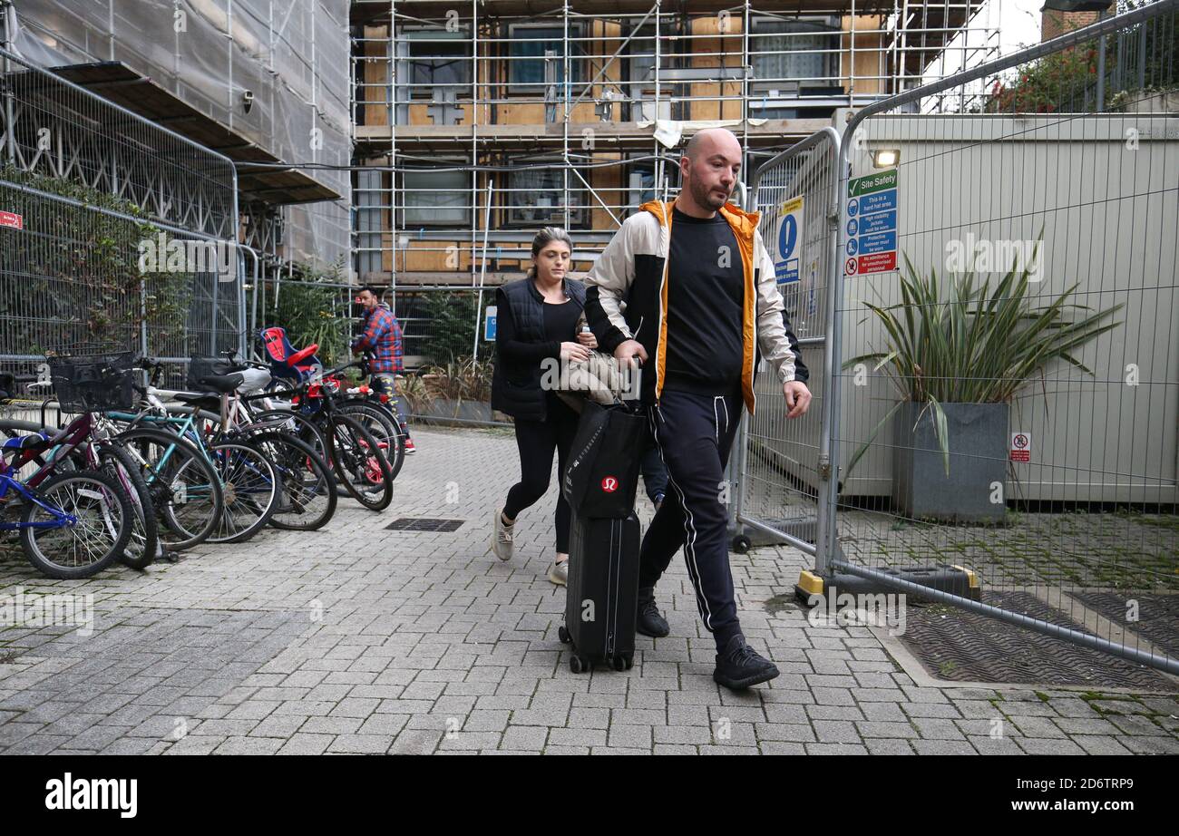 Residents of Block B in the Paragon estate in Brentford, west London, leave to go to a hotel, after the they were asked to 'immediately' leave their homes due to fire safety concerns. Stock Photo