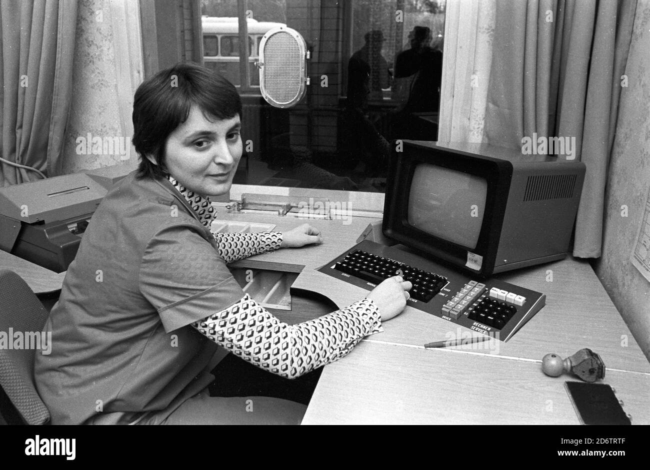 18 July 1984, Saxony, Eilenburg: An employee in the ticket office of the Eilenburg station of the Deutsche Reichsbahn in the mid 1980s. She shows the computer-supported ticket issuing technology. Exact date of recording not known. Photo: Volkmar Heinz/dpa-Zentralbild/ZB Stock Photo