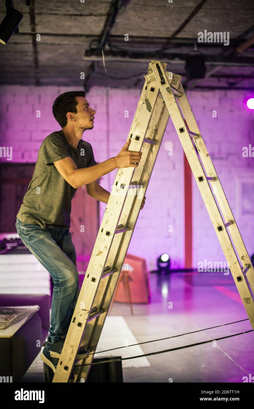 Theater lighting technician electric engineer adjusting focus of