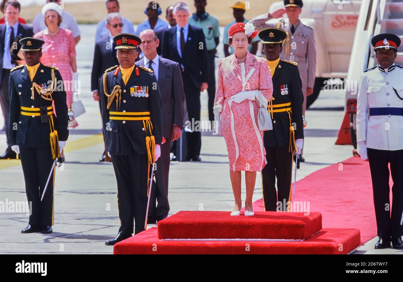 Queen Elizabeth II standing on the red carpet with a party of dignitaries before her departure at Grantley Adams International Airport, Barbados after a Royal tour 8-11th March 1989 Stock Photo