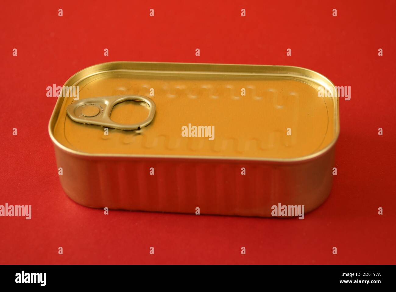 sealed food tin with ring pull isolated on a red background Stock Photo