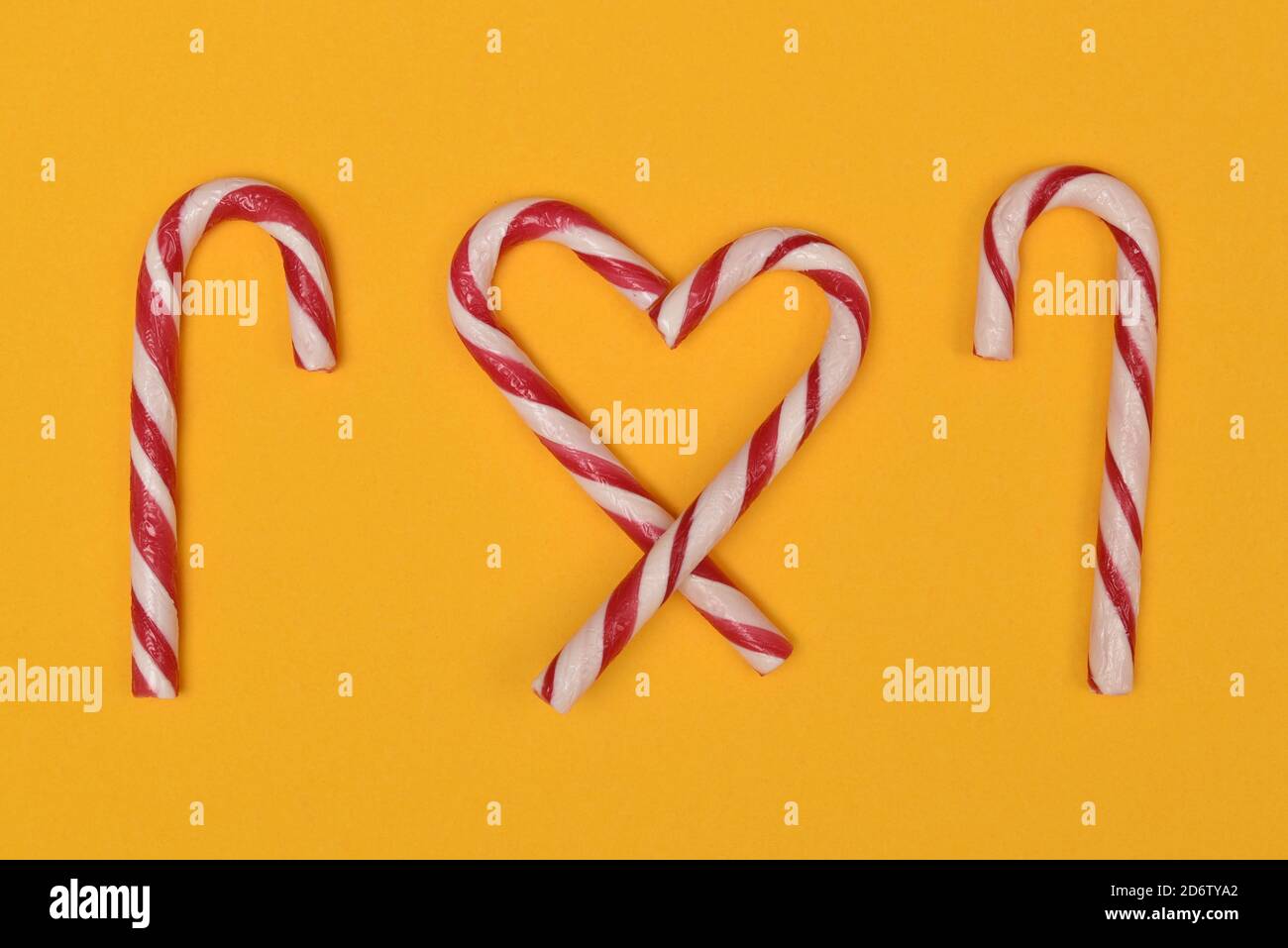 Candy cane heart and canes on a yellow background Stock Photo