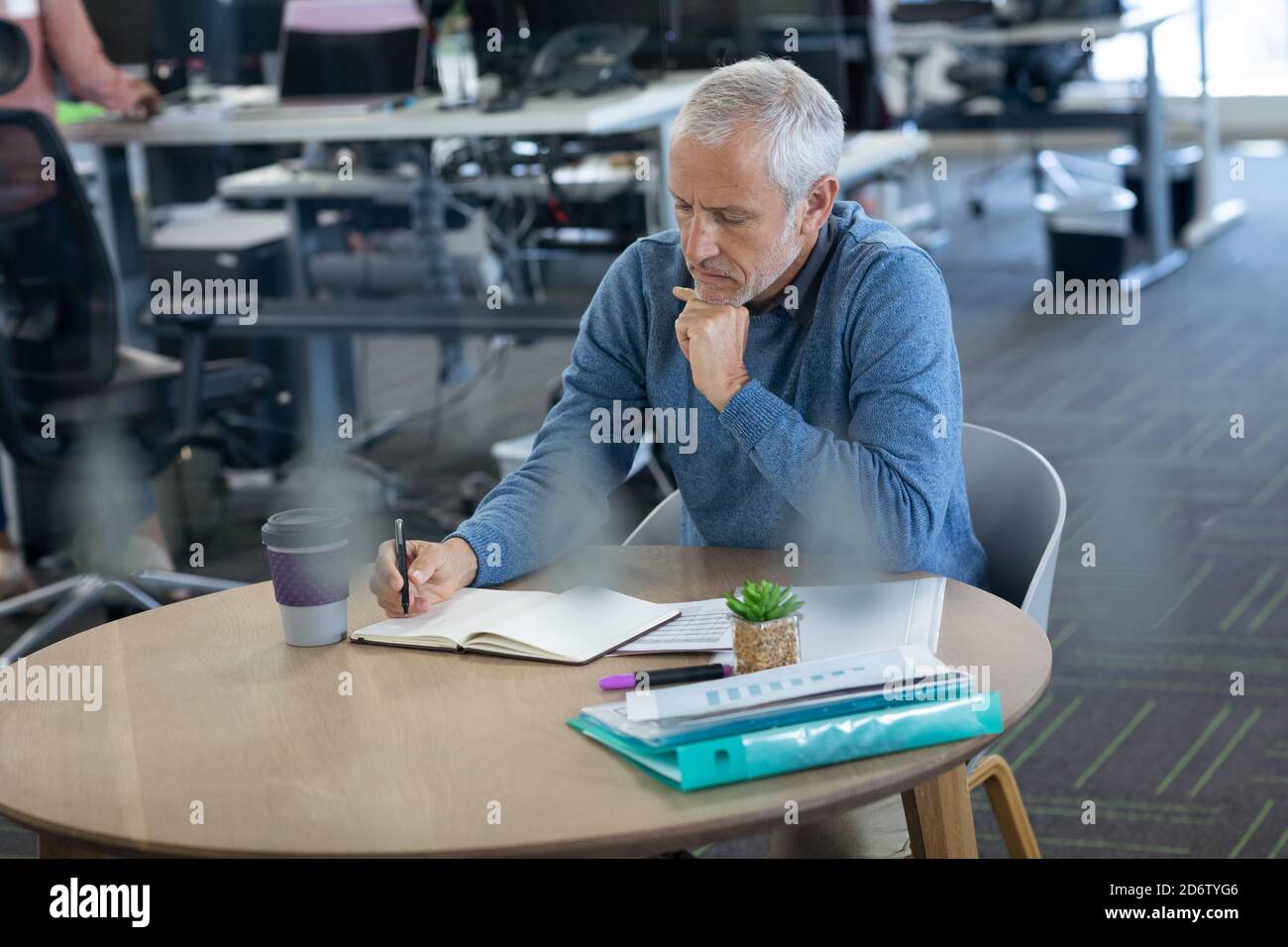 Senior businessman taking notes at office Stock Photo