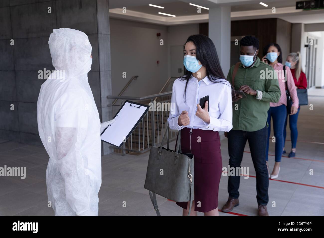 Group of people wearing face masks standing in queue Stock Photo