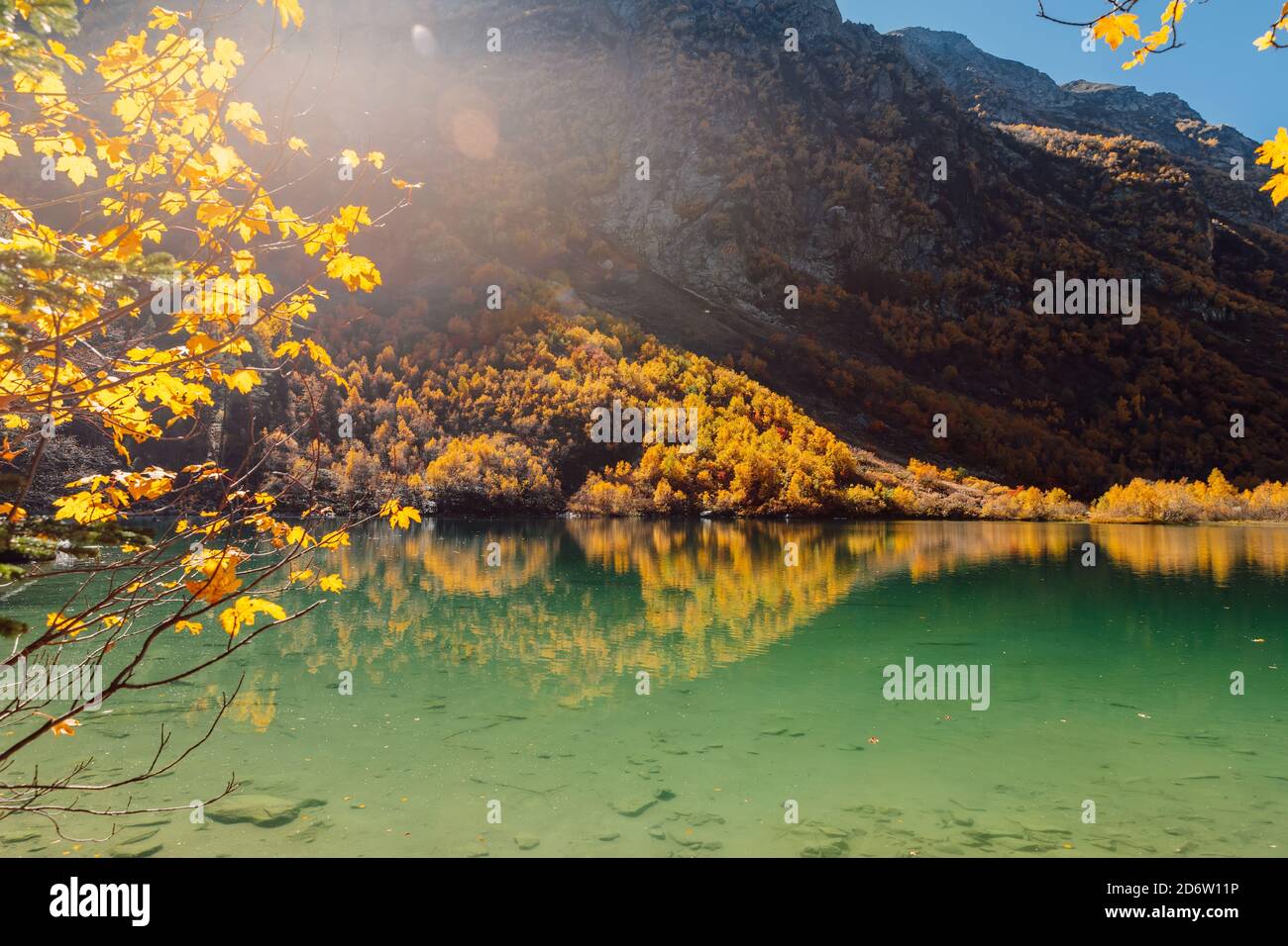 Mountain lake with transparent water and colorful autumnal trees ...