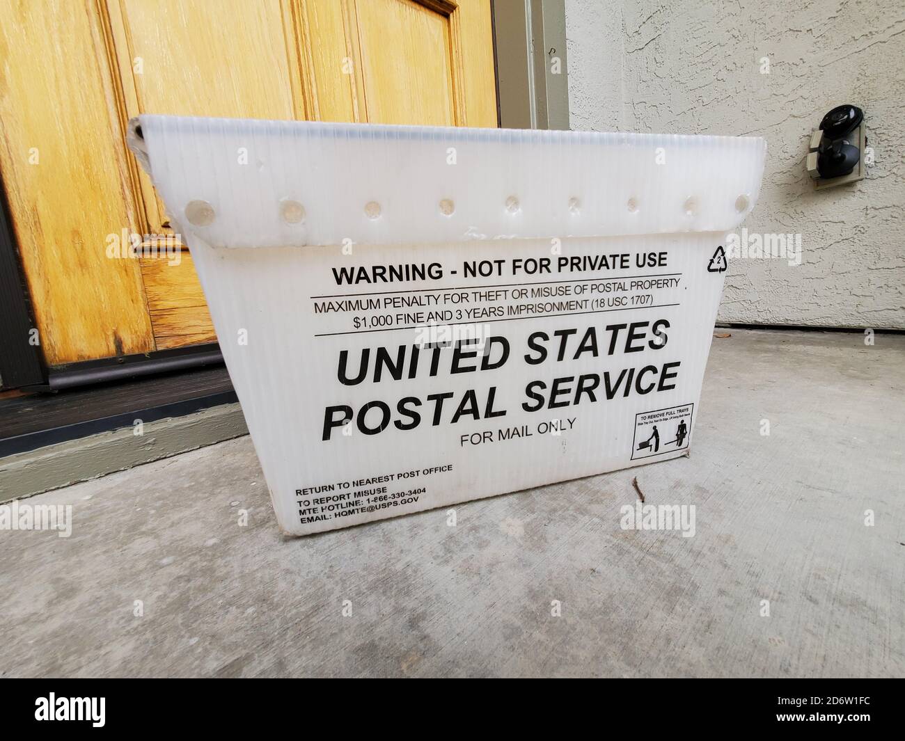 Large plastic mail tote for United States Postal Service (USPS) on front step of suburban home, San Ramon, California, September 14, 2020. () Stock Photo