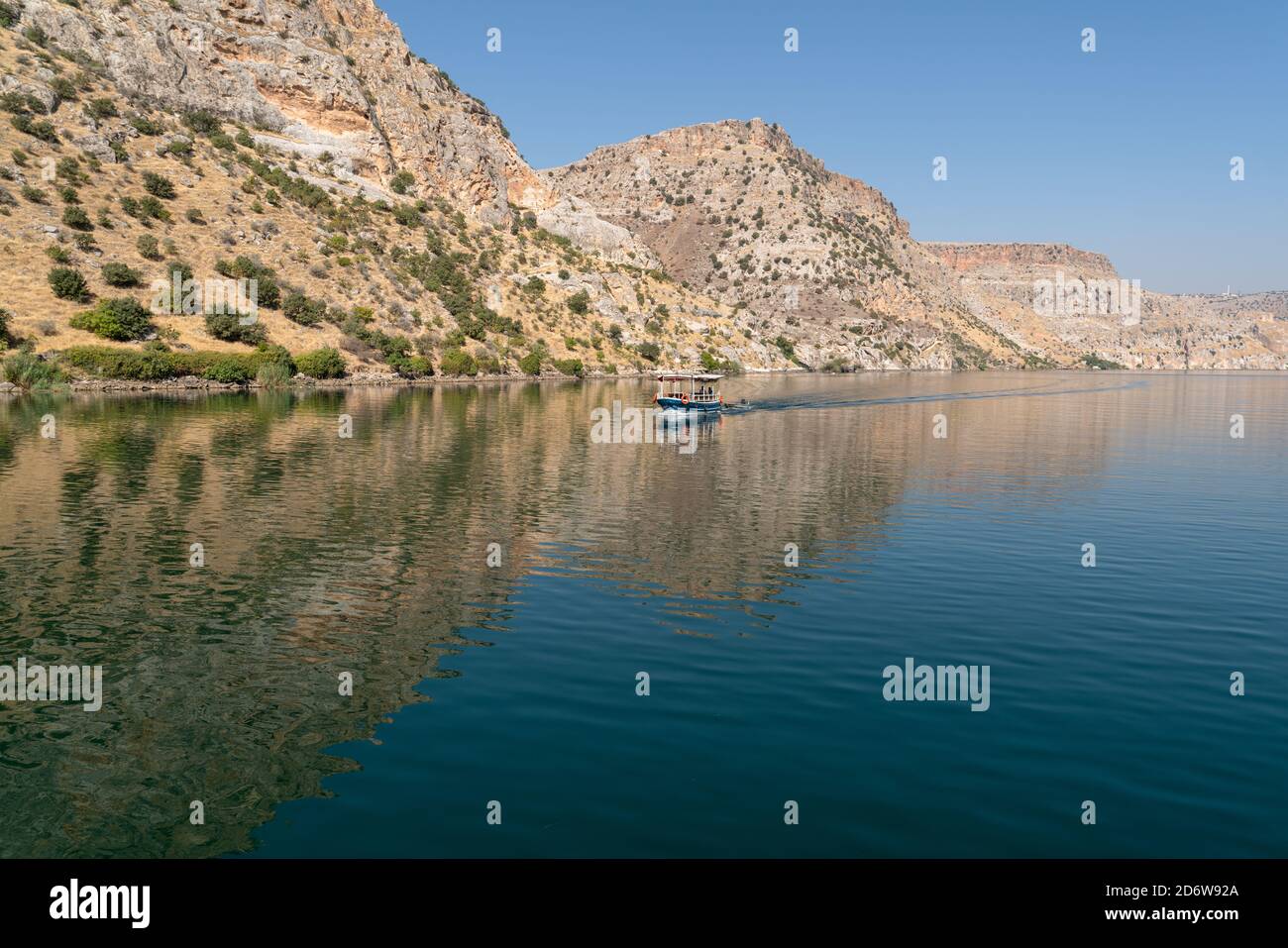 Halfeti, Sanliurfa/ Turkey- September 15 2020: One boat on Firat river and hills in background. Stock Photo