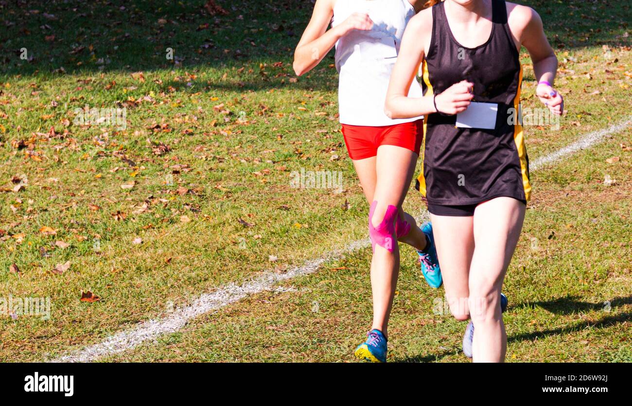 Two high school cross country runners are battling with each other on a