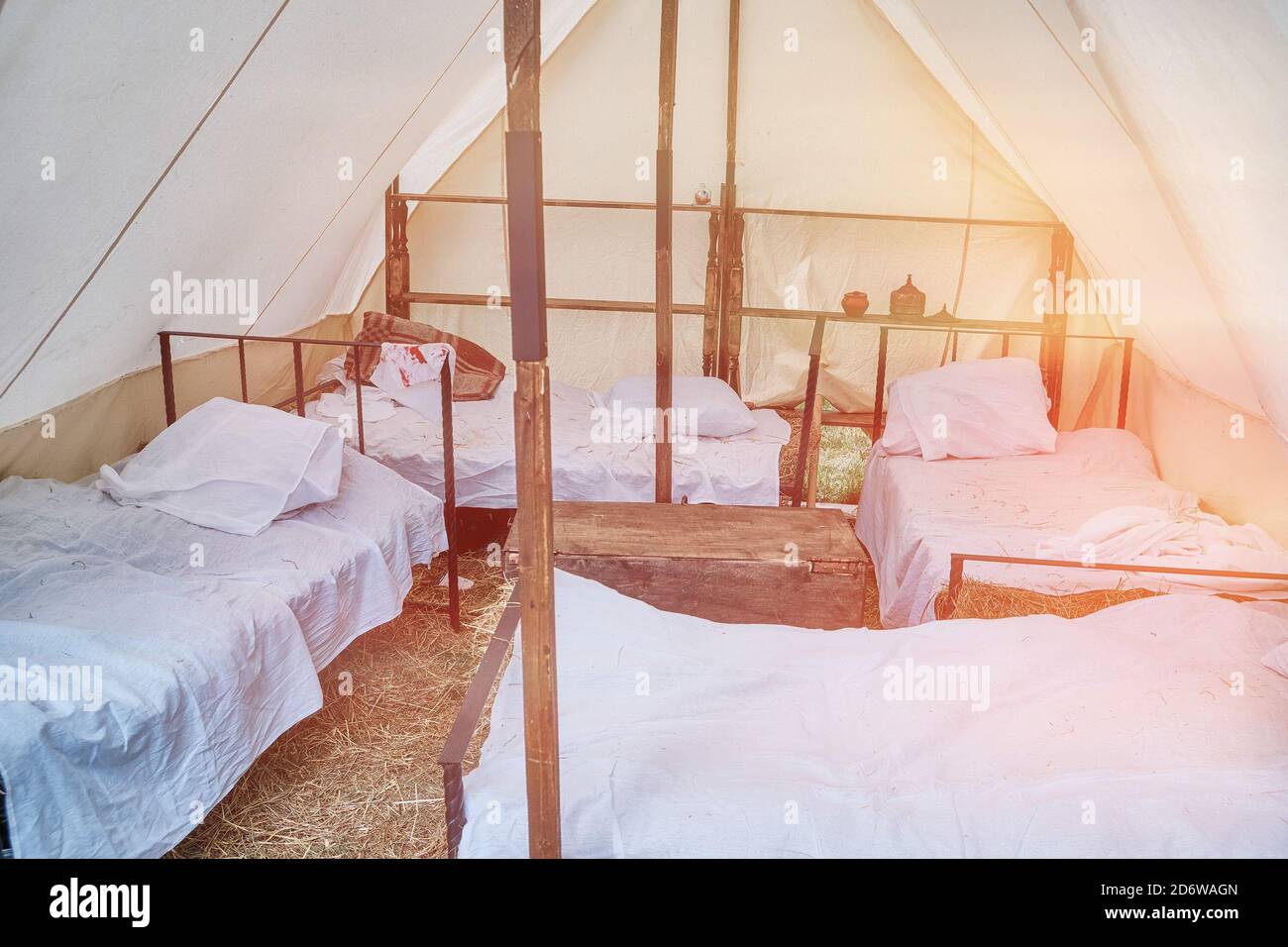 Beds under a large tent retro field hospital. Military field medicine