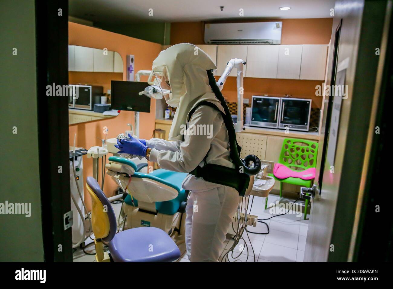 Manila, Philippines. 19th Oct, 2020. Dr. Maureen P. Ines-Manzano, a dentist, is seen while wearing a powered air-purifying respirator (PAPR) suit inside her clinic in Manila, the Philippines, on Oct. 19, 2020. Patients of Dr. Manzano has dubbed her the 'astronaut dentist' because of her resemblance to a spacewoman while wearing her PAPR suit to protect her patients and herself from the COVID-19 disease. Credit: Rouelle Umali/Xinhua/Alamy Live News Stock Photo