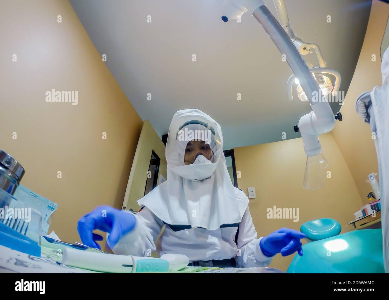 Manila, Philippines. 19th Oct, 2020. Dr. Maureen P. Ines-Manzano, a dentist, prepares her dental equipment while wearing a powered air-purifying respirator (PAPR) suit inside her clinic in Manila, the Philippines, on Oct. 19, 2020. Patients of Dr. Manzano has dubbed her the 'astronaut dentist' because of her resemblance to a spacewoman while wearing her PAPR suit to protect her patients and herself from the COVID-19 disease. Credit: Rouelle Umali/Xinhua/Alamy Live News Stock Photo