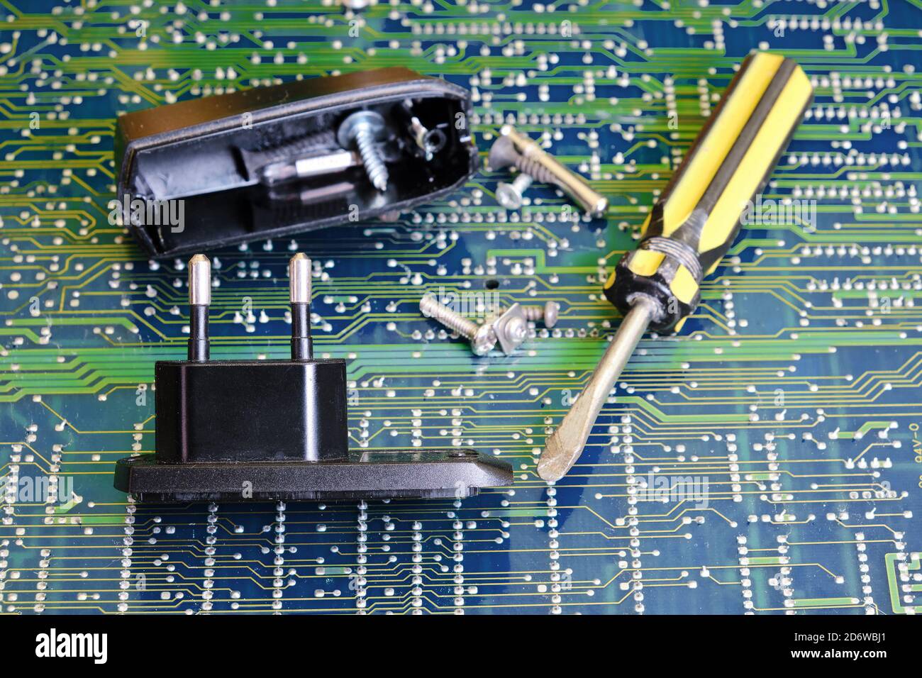 Power adapter repair screwdriver against electronic circuit board Stock Photo
