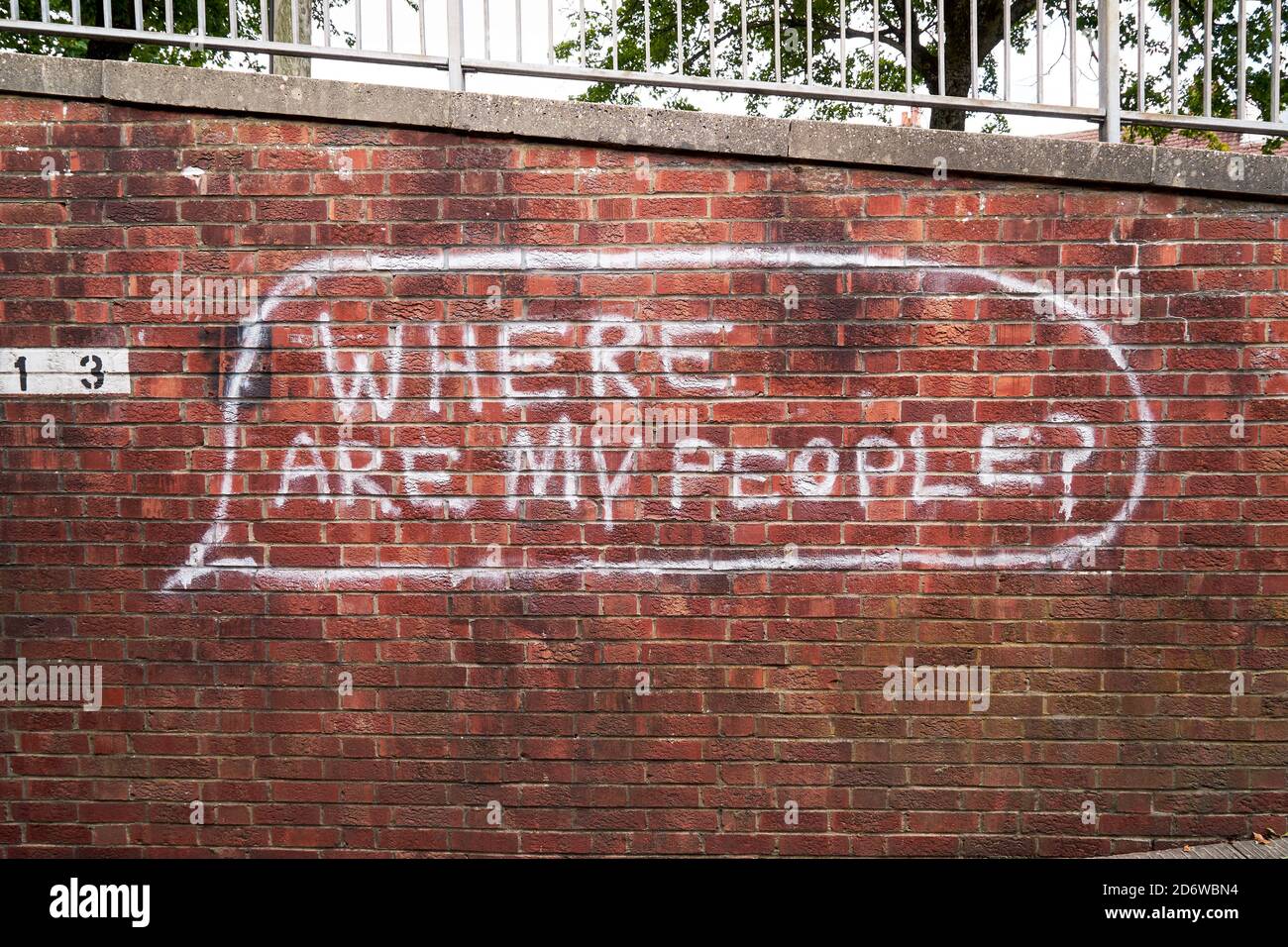 White painted graffiti on red brick wall Stock Photo