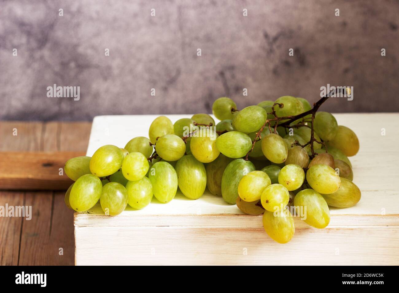 Amber bunch of grapes on a gray concrete background. Stock Photo