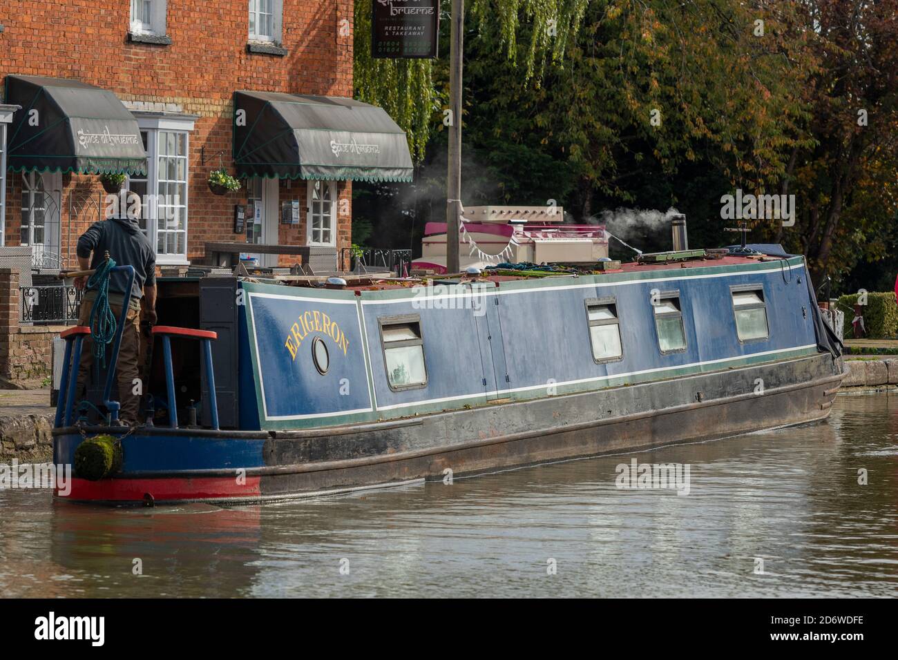man at the helm or tiller of a traditional canal narrow boat ot barge