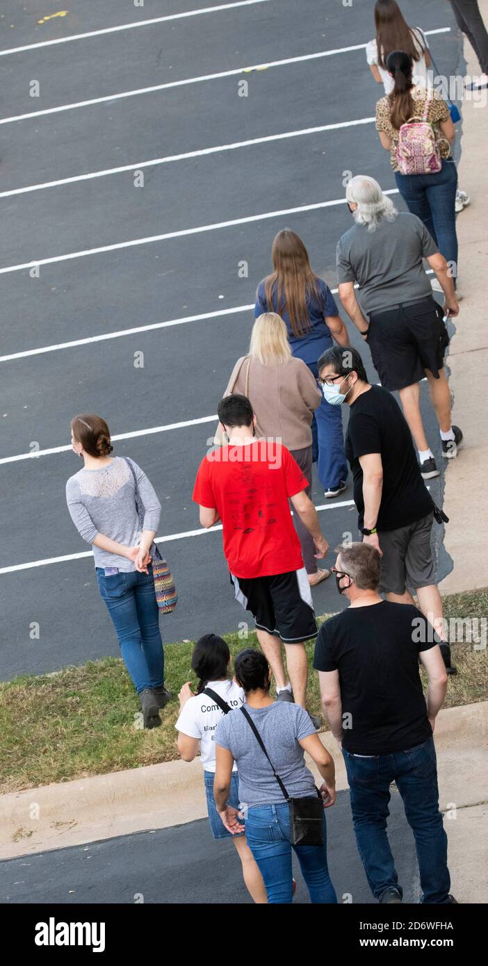 Austin, Texas USA, Oct. 13 2020: Masked-up Texans wait patiently in line at the Arboretum area of north Austin at an early voting site to cast ballots in the 2020 presidential election. Officials are reporting record numbers of early voters with almost 40,000 per day citywide. Stock Photo