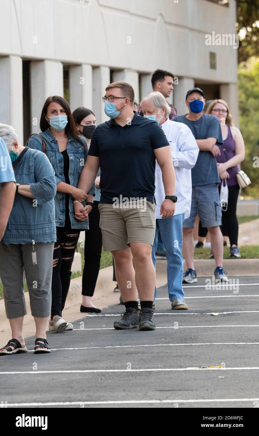 Austin, Texas USA, Oct. 13 2020: Masked-up Texans wait patiently in line at the Arboretum area of north Austin at an early voting site to cast ballots in the 2020 presidential election. Officials are reporting record numbers of early voters with almost 40,000 per day citywide. Stock Photo