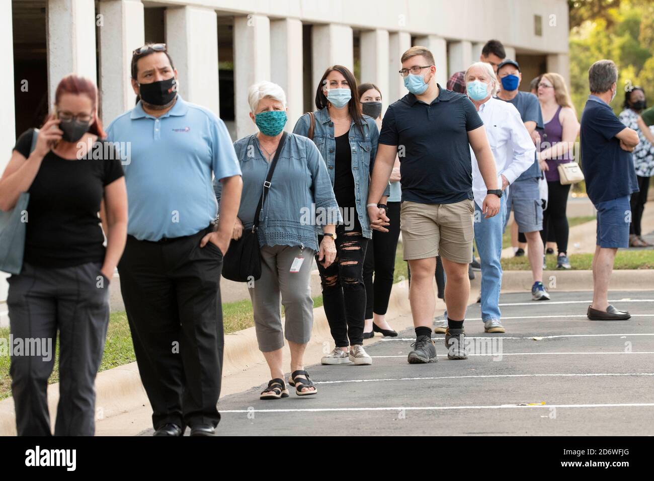 Austin, Texas USA, Oct. 13 2020: Masked-up Texans wait patiently in line at the Arboretum area of north Austin at an early voting site to cast ballots in the 2020 presidential election. Officials are reporting record numbers of early voters with almost 40,000 per day citywide. Stock Photo