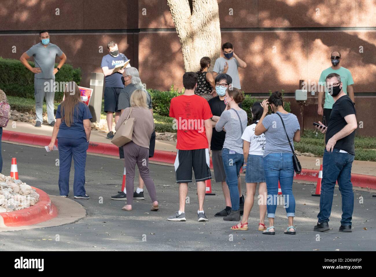 Austin, Texas USA, Oct. 13 2020: Masked-up Texans wait patiently in line at the Arboretum area of north Austin at an early voting site to cast ballots in the 2020 presidential election. Officials are reporting record numbers of early voters with almost 40,000 per day citywide. Stock Photo