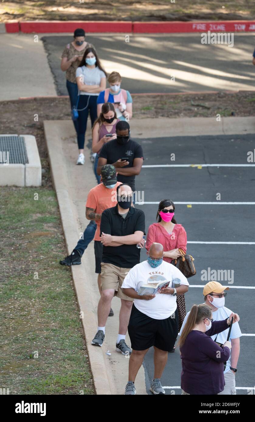 Austin, Texas USA, Oct. 13 2020: Masked-up Texans wait patiently in line at the Arboretum area of north Austin at an early voting site to cast ballots in the 2020 presidential election. Officials are reporting record numbers of early voters with almost 40,000 per day citywide. Stock Photo