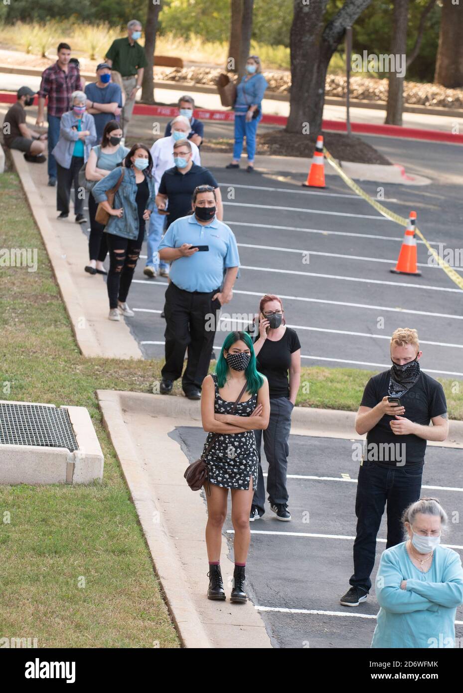 Austin, Texas USA, Oct. 13 2020: Masked-up Texans wait patiently in line at the Arboretum area of north Austin at an early voting site to cast ballots in the 2020 presidential election. Officials are reporting record numbers of early voters with almost 40,000 per day citywide. Stock Photo