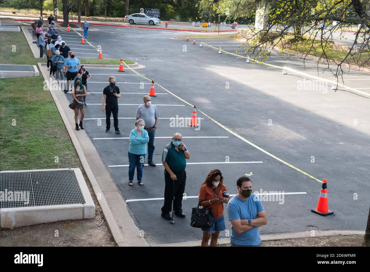 Austin, Texas USA, Oct. 13 2020: Masked-up Texans wait patiently in line at the Arboretum area of north Austin at an early voting site to cast ballots in the 2020 presidential election. Officials are reporting record numbers of early voters with almost 40,000 per day citywide. Stock Photo