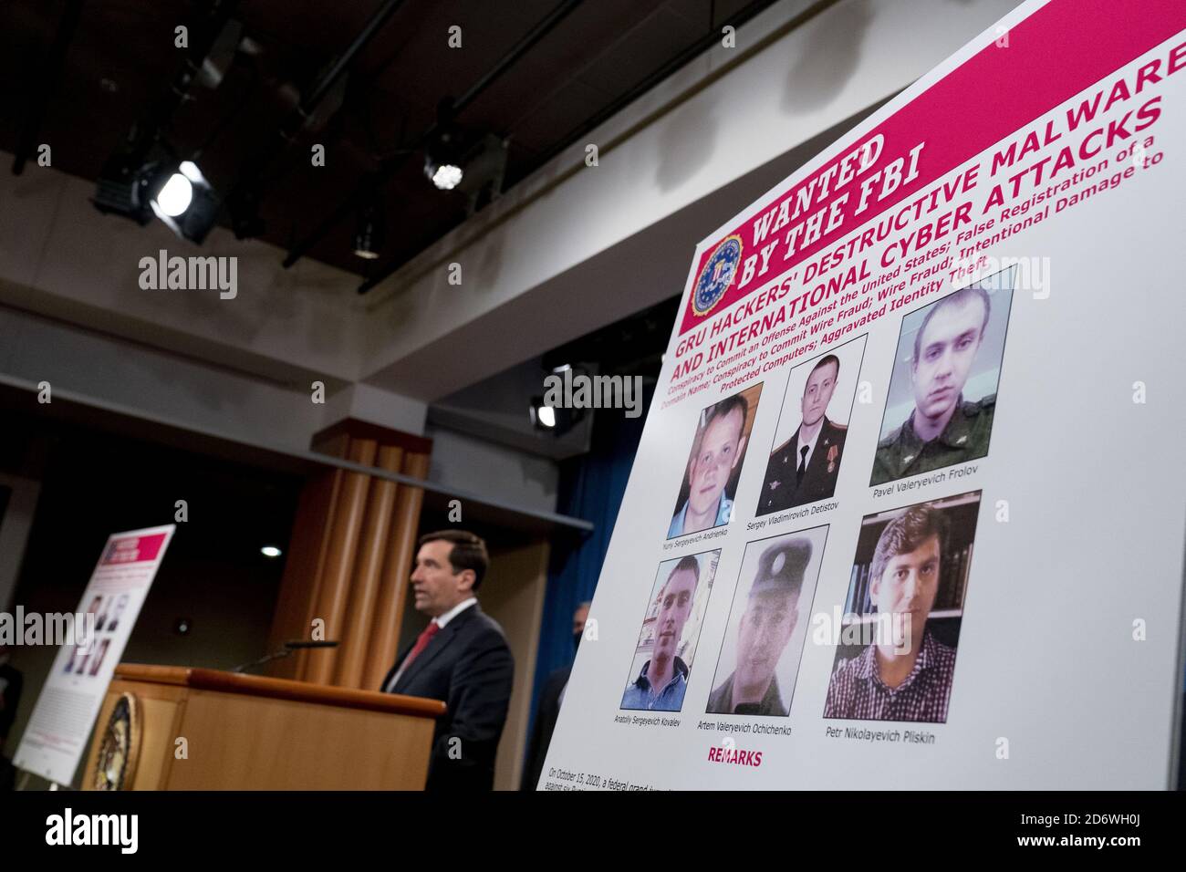 Washington, United States. 19th Oct, 2020. A poster showing six wanted Russian military intelligence officers is displayed as Assistant Attorney General for the National Security Division John Demers, left, takes the podium to speak at a news conference at the Department of Justice, Monday, October 19, 2020, in Washington, DC. Six Russian Military Intelligence agency (GRU) officers were charged by a Pittsburgh grand jury in regards to computer hacking. Pool Photo by Andrew Harnik/UPI Credit: UPI/Alamy Live News Stock Photo