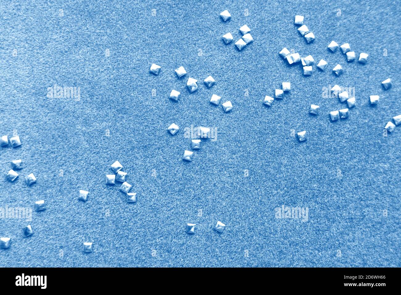 Blue paper background with shiny square beads. Glitters scattered on ...