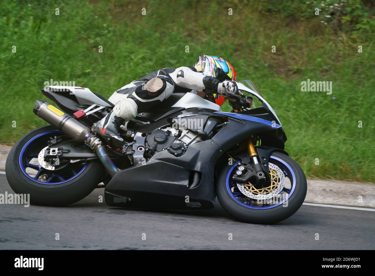 man riding motorcycle in asphalt road. Motorcyclist at black and white sport motorcycle. Stock Photo