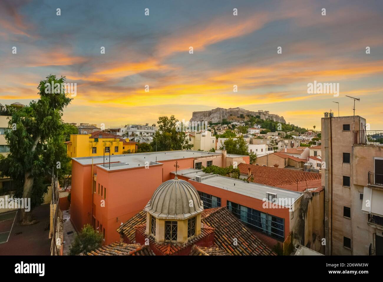 The ancient Acropolis and Parthenon on Acropolis hill viewed from the Plaka region below in the city of Athens, Greece at sunset. Stock Photo