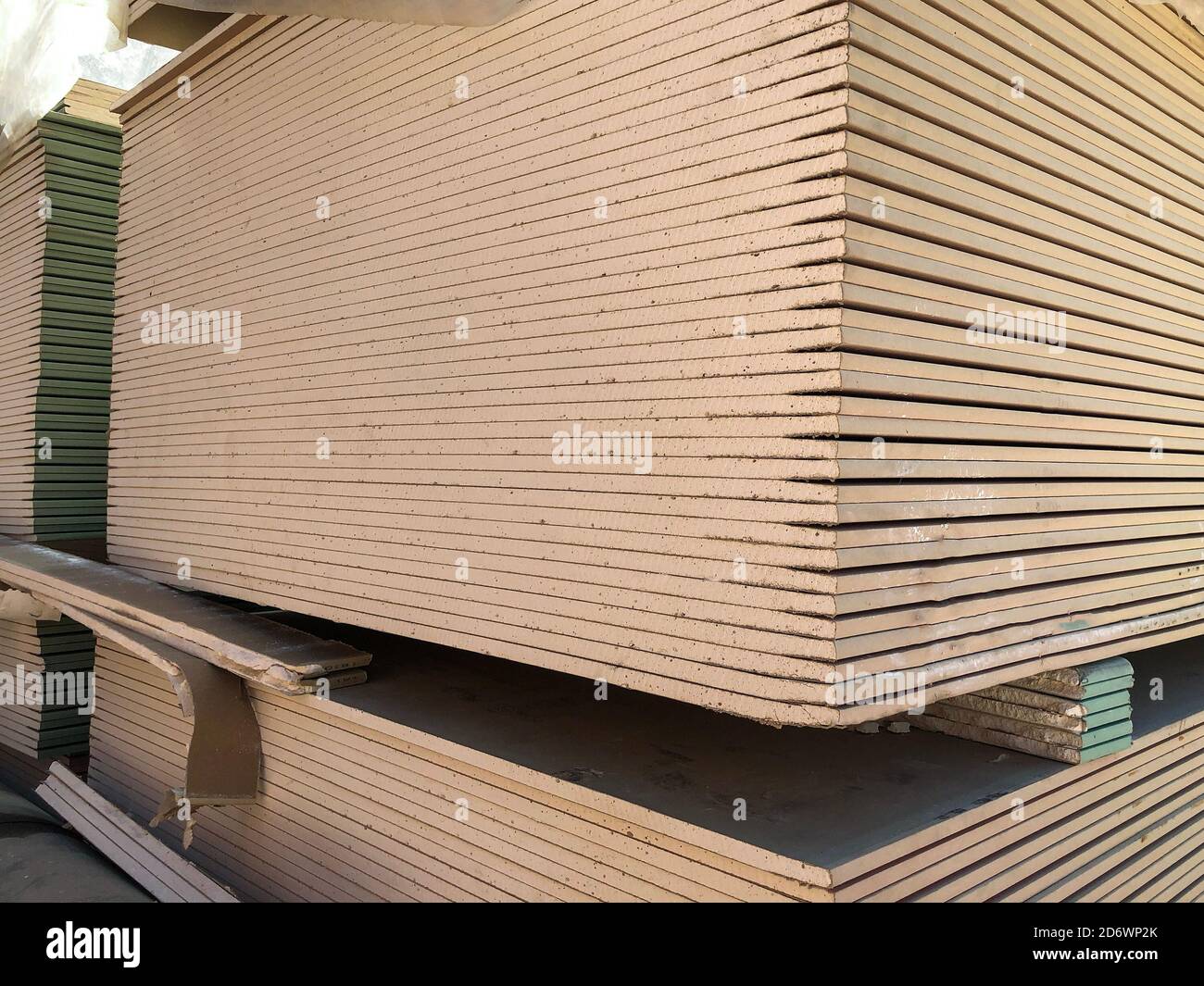 Piled sheets of drywall. Stacked plasterboard sheets. Gypsum cardboard