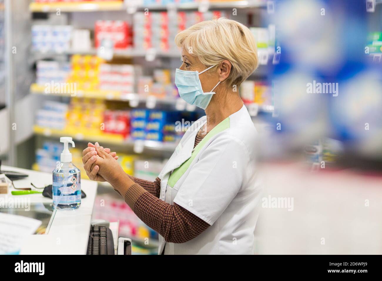 Pharmacist using hydroalcoholic gel during the Covid-19 pandemic, France. Stock Photo