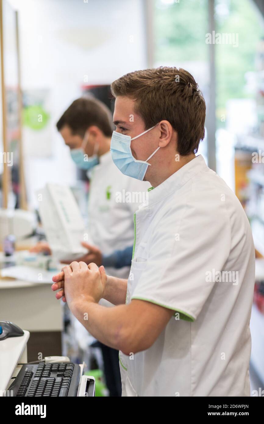 Pharmacist using hydroalcoholic gel during the Covid-19 pandemic, France. Stock Photo