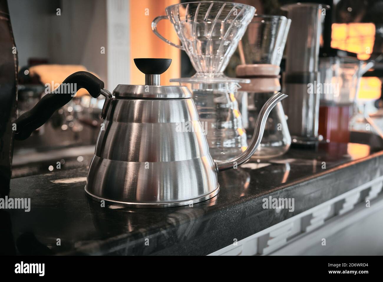 Chrome coffee pot and other utensils for making coffee is on cafe bar