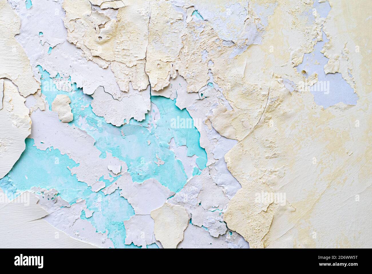 Colorful background. Layers of peeling plaster of different colors. Yellow and blue Stock Photo