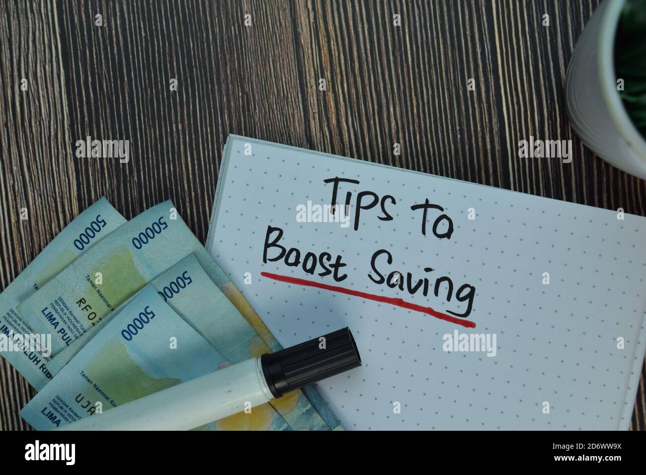 Tips To Boost Saving write on a book isolated on Wooden Table. Financial Concept Stock Photo