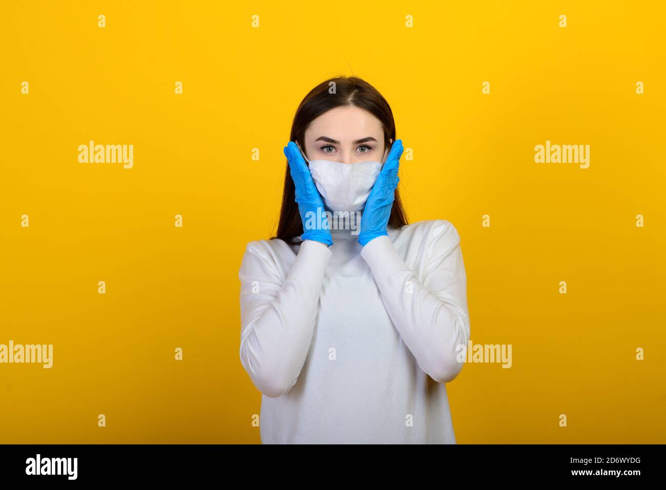 Girl in medical gloves dress protective mask on her face on studio ...