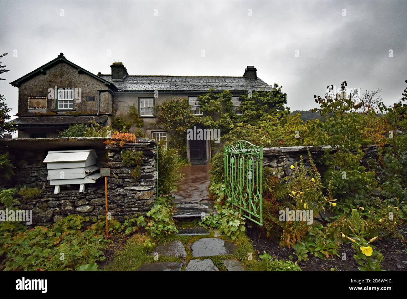 Hill Top, the home of children's author, Beatrix Potter, in the Lake District, England. Seen from the historically recreated garden with green gate. Stock Photo