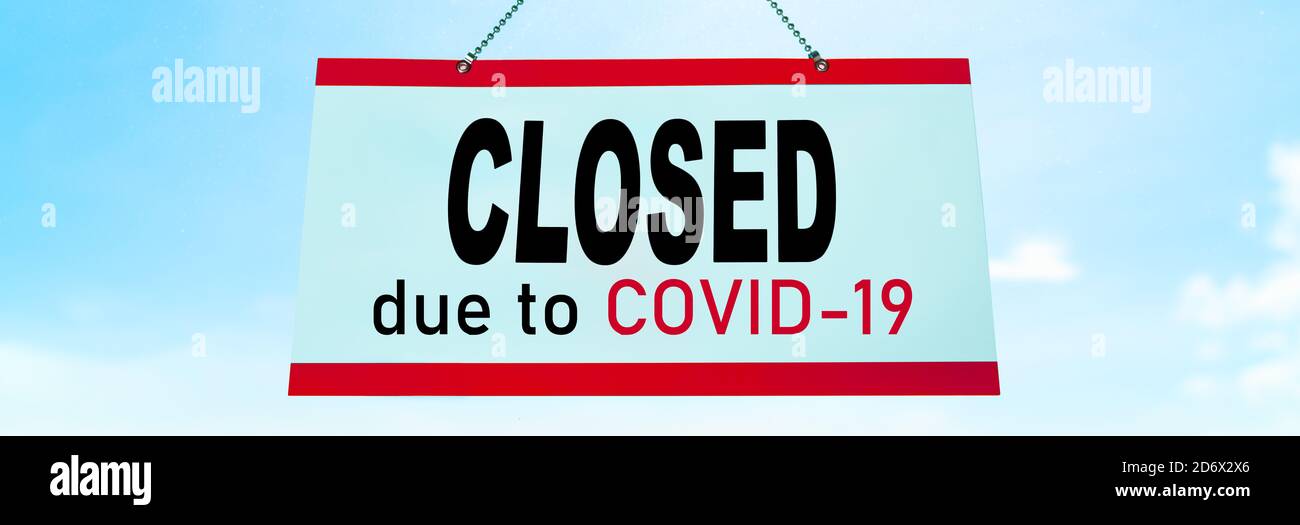 Closed COVID-19 sign hanging on window of shop. Businesses going bankrupt, barber shop, restaurants, hotels, stores, non essential services leading to Stock Photo