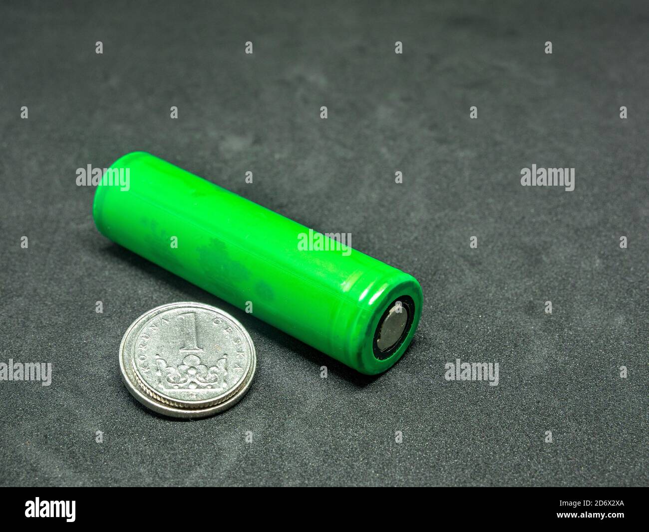 Green li-ion battery and small coins - selective focus Stock Photo