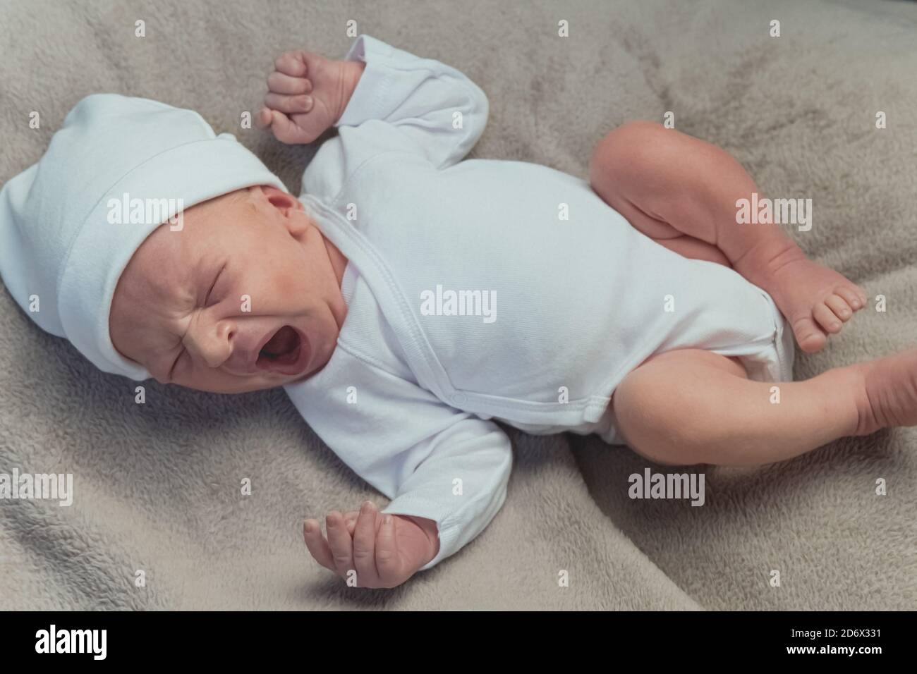 Cute newborn baby yawning and stretching on the blanket. High quality photo Stock Photo