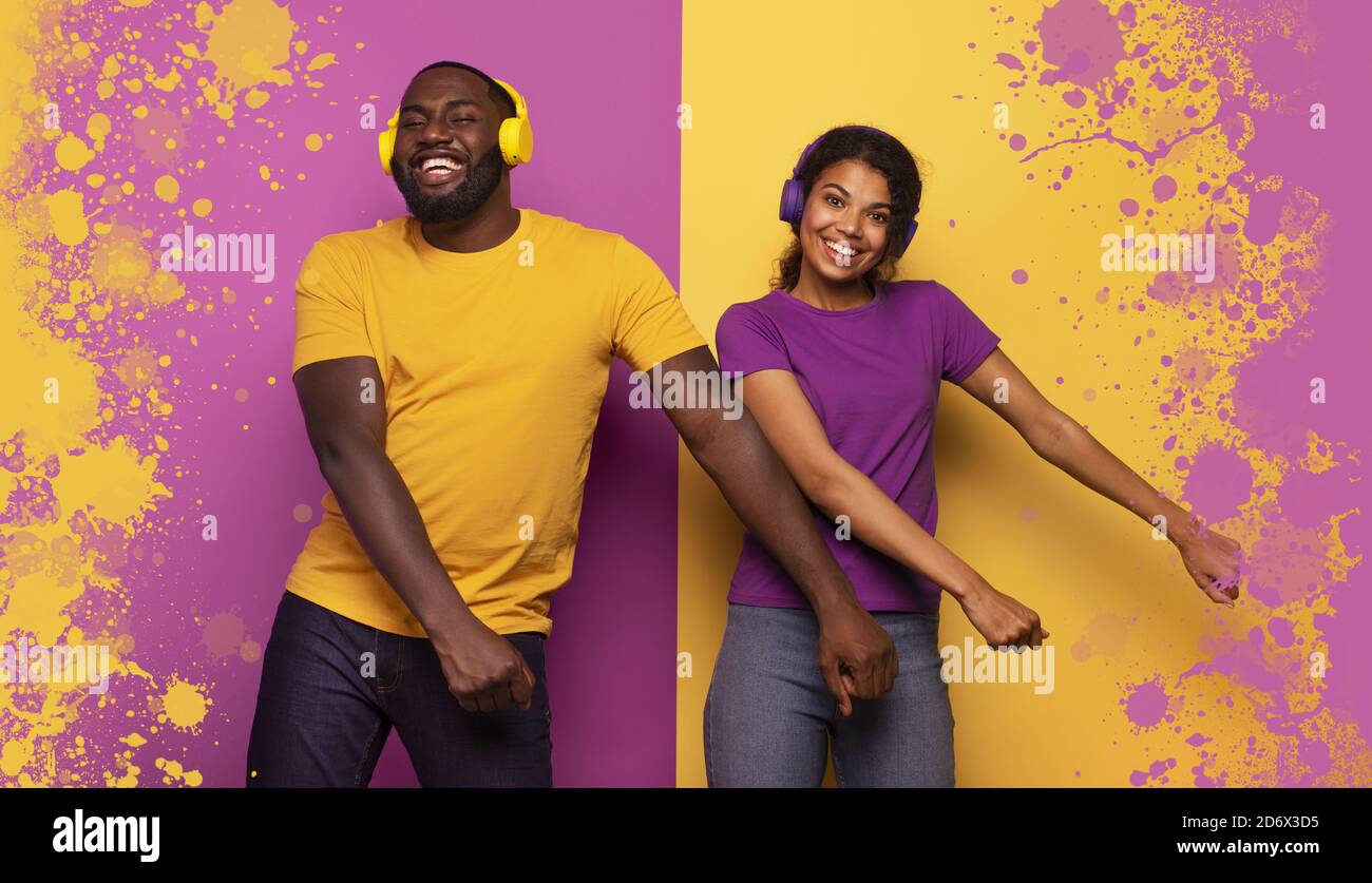 Couple with headset listen to music and dance with energy on violet and yellow background Stock Photo