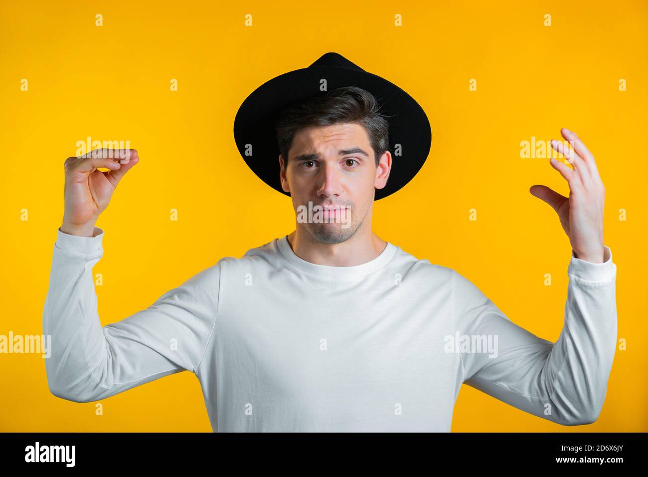 Handsome man showing bla-bla-bla gesture with hands isolated on yellow background. Empty promises, blah concept. Lier. Stock Photo