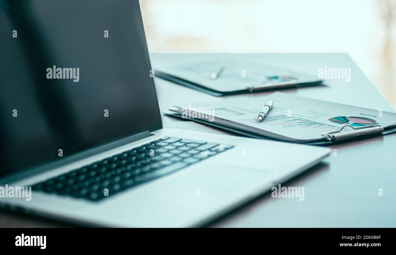 close up. a laptop computer and financial graph on the desktop Stock ...