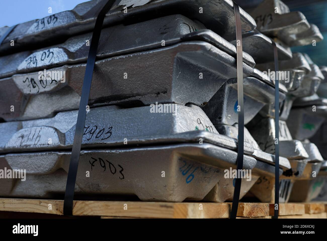Aluminum ingots or billets on a wooden pallet. Selective focus. Stock Photo