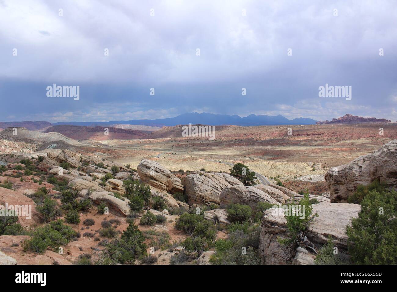 Classic southwest desert landscape featuring wide valleys and deep canyons with the rocky mountains in the background; Arches National Park, Utah Stock Photo
