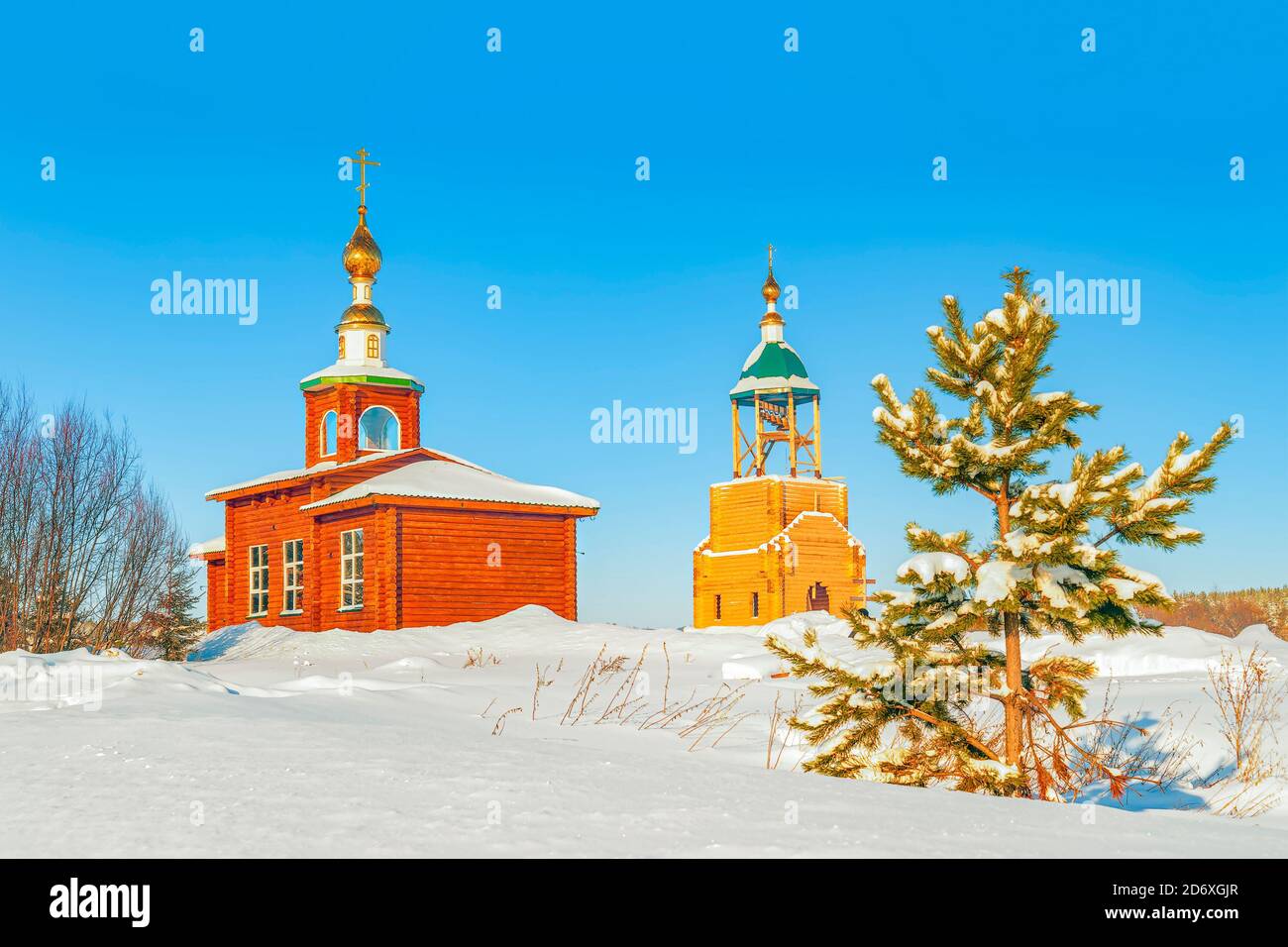 Small wooden Russian Orthodox church and bell tower in an early winter evening. Arkhangelsk Oblast. Russia Stock Photo